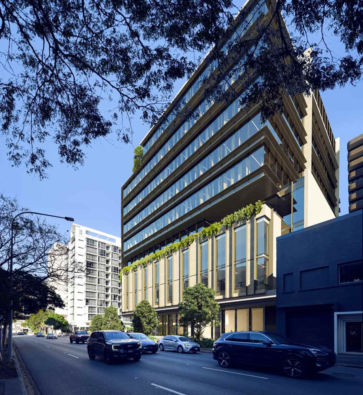 View of the 949 Ann Street tower from Ann Street looking west at dusk showing the glazed facade and street level landscaping
